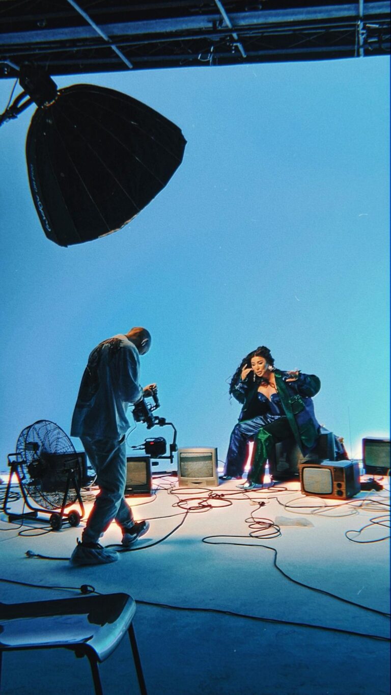 Dynamic music video shoot featuring equipment and vibrant lights in studio.